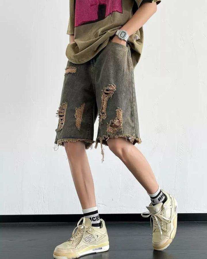 Dark washed heavy-ripped denim shorts, side-front showing ripped panels