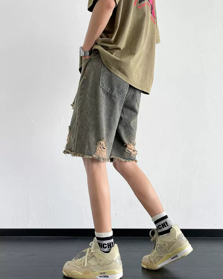 Dark washed heavy-ripped denim shorts, side showing frayed hem