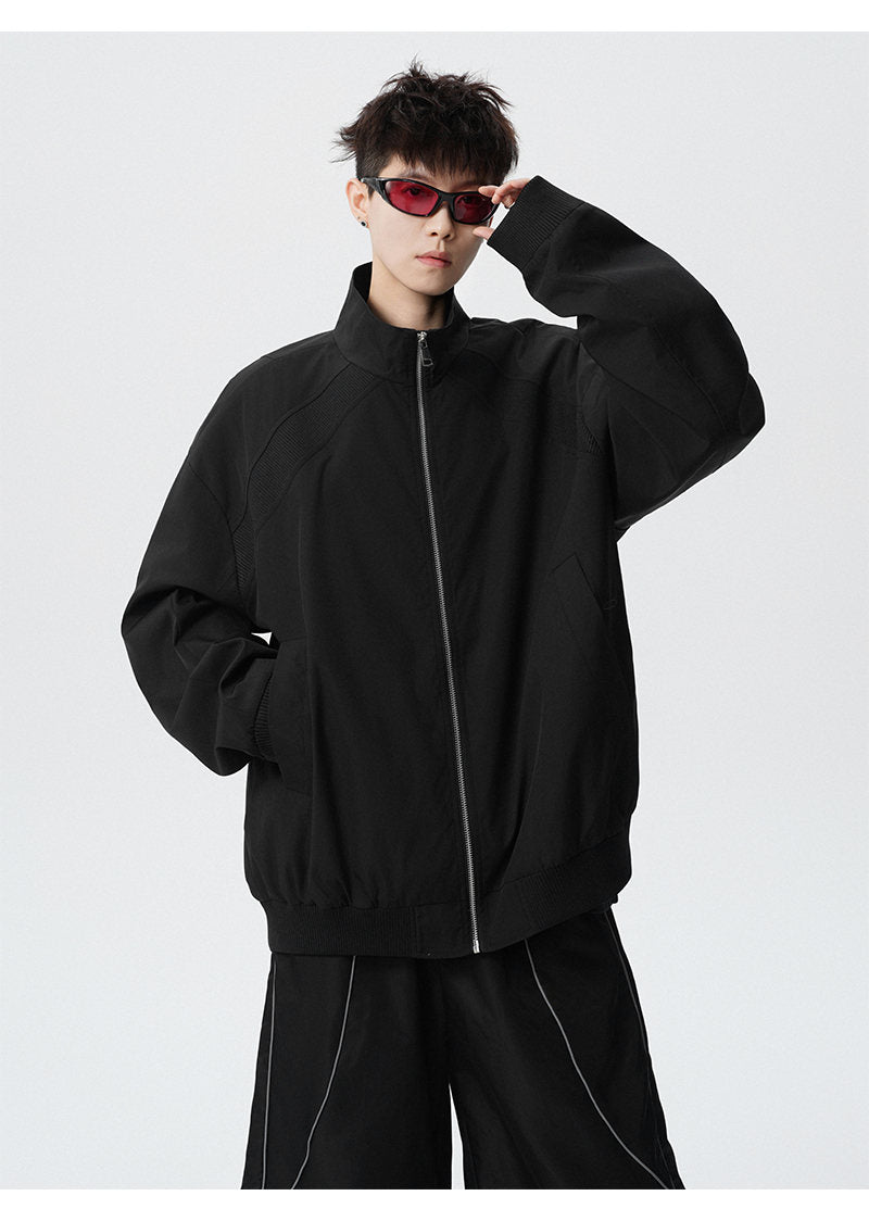 Paneled stand-collar jacket, close-up view of the black collar and zipper
