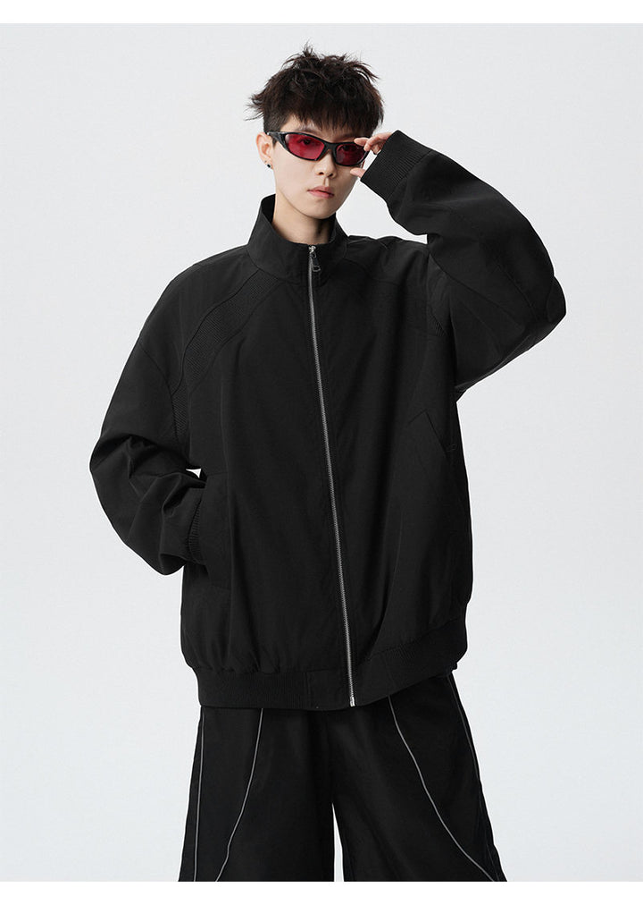 Paneled stand-collar jacket, close-up view of the black collar and zipper